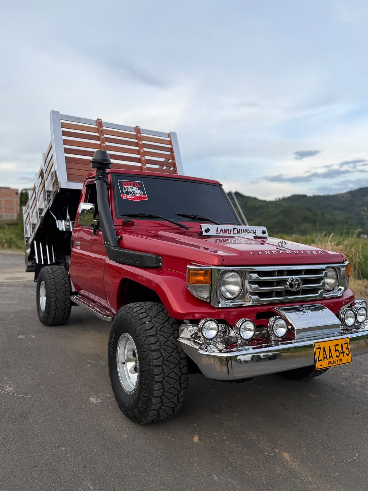 Toyota Land Cruiser 4.5 diésel roja de estacas con snorkel, exploradoras y platón de madera, premio mayor de la rifa